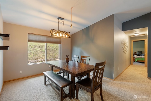 dining area with light colored carpet and vaulted ceiling