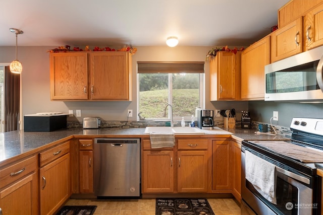 kitchen featuring decorative light fixtures, stainless steel appliances, sink, and light tile patterned floors