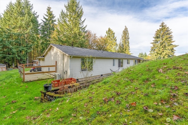 exterior space featuring a wooden deck and a lawn