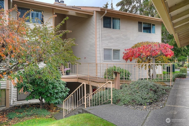 rear view of house with stairway and a deck