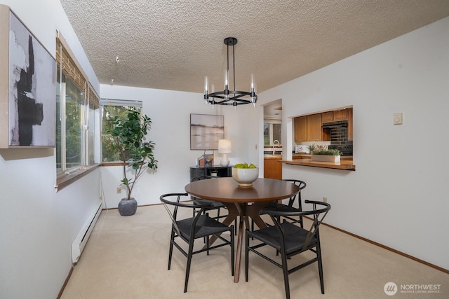 dining area featuring a baseboard heating unit, baseboards, a chandelier, light carpet, and a textured ceiling