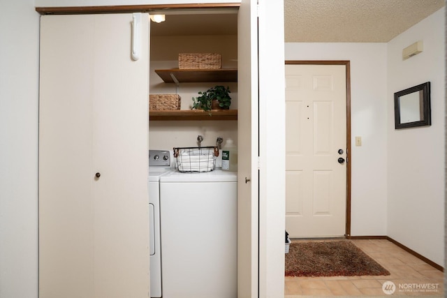 laundry room featuring a textured ceiling, laundry area, baseboards, and washing machine and clothes dryer