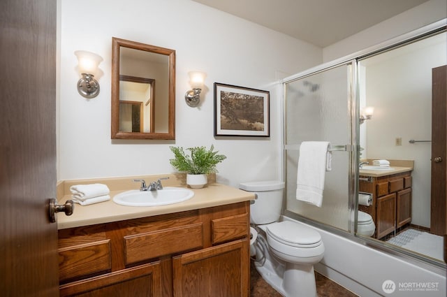 full bathroom featuring vanity, toilet, and combined bath / shower with glass door