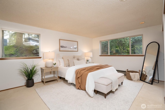 bedroom featuring light carpet, baseboard heating, a textured ceiling, and baseboards