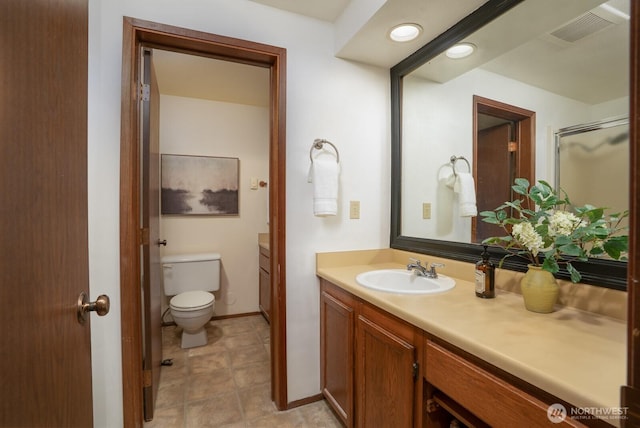 bathroom featuring visible vents, baseboards, toilet, and vanity