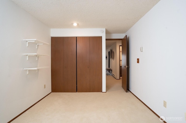 unfurnished bedroom with a closet, baseboards, light colored carpet, and a textured ceiling