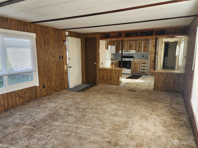 kitchen featuring kitchen peninsula, wooden walls, and white appliances