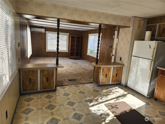 interior space featuring an AC wall unit, plenty of natural light, and wood walls