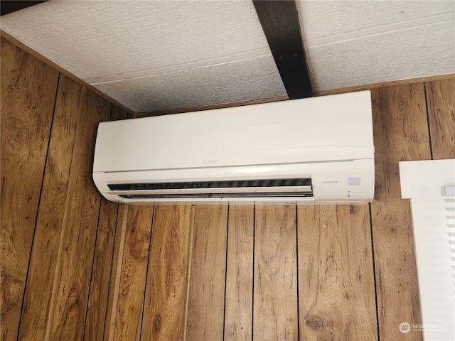 interior details featuring a wall mounted air conditioner and wood walls