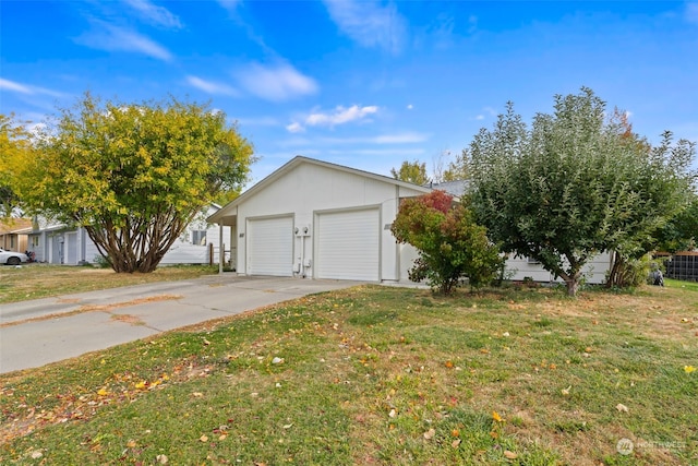 view of side of property featuring a yard, a garage, and an outdoor structure