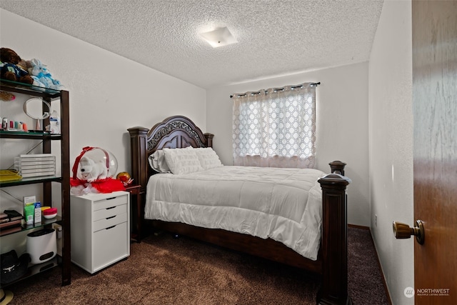 bedroom with a textured ceiling and dark colored carpet