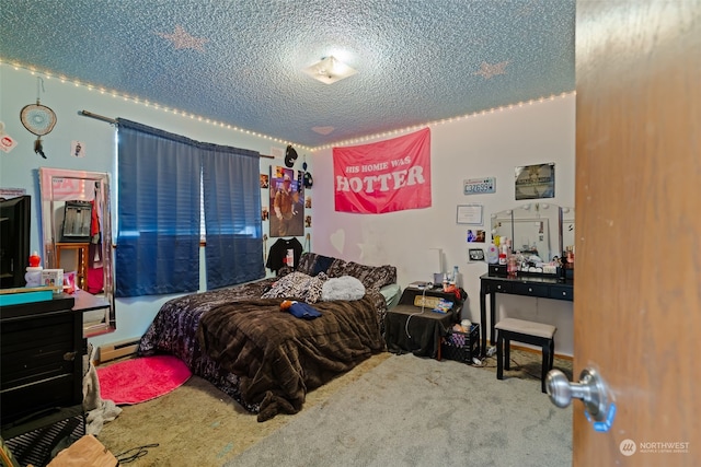 bedroom featuring a textured ceiling, baseboard heating, and carpet flooring