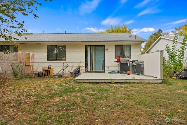 back of house featuring a wooden deck and a yard