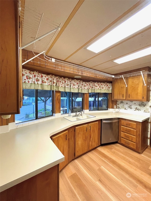 kitchen with light hardwood / wood-style floors, decorative backsplash, dishwasher, and kitchen peninsula