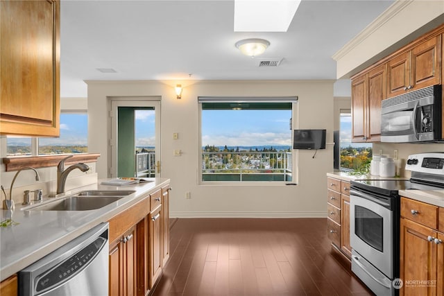 3201 Pacific Ave Unit 1201, Tacoma, WA 98418 - kitchen featuring appliances with stainless steel finishes, a sink, a skylight, light countertops, and ornamental molding