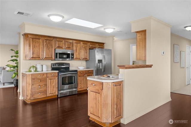 3201 Pacific Ave Unit 1201, Tacoma, WA 98418 - kitchen featuring appliances with stainless steel finishes, dark wood-style flooring, light countertops, brown cabinetry, and ornamental molding