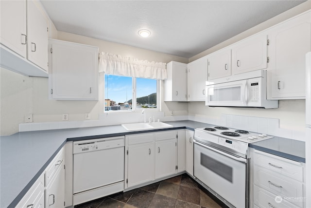 kitchen with a textured ceiling, white cabinets, sink, and white appliances