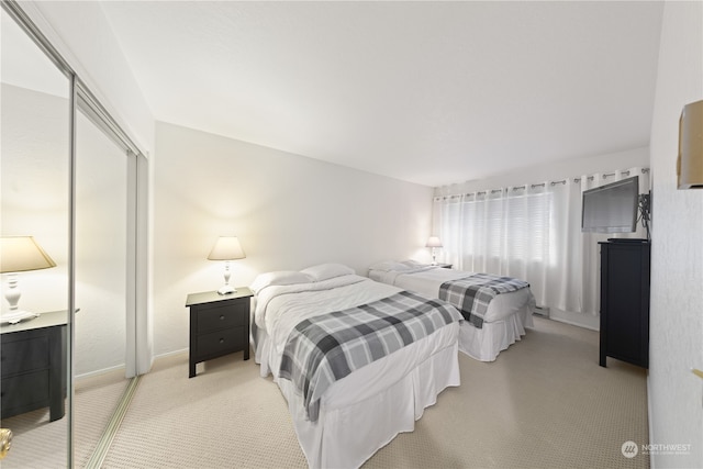 bedroom featuring a closet and light colored carpet