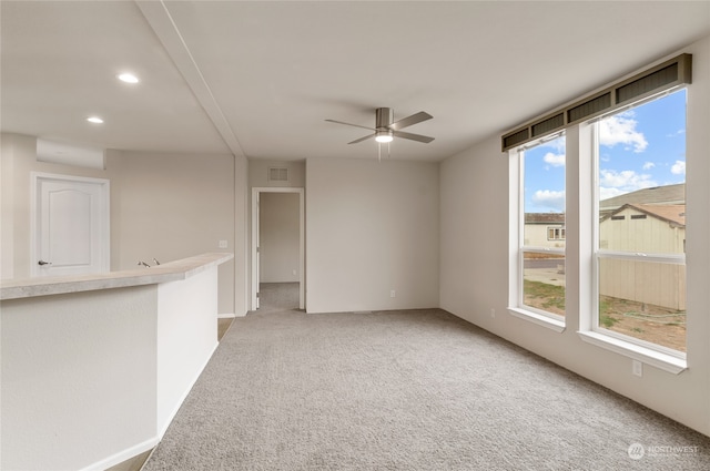 empty room featuring carpet floors, plenty of natural light, and ceiling fan