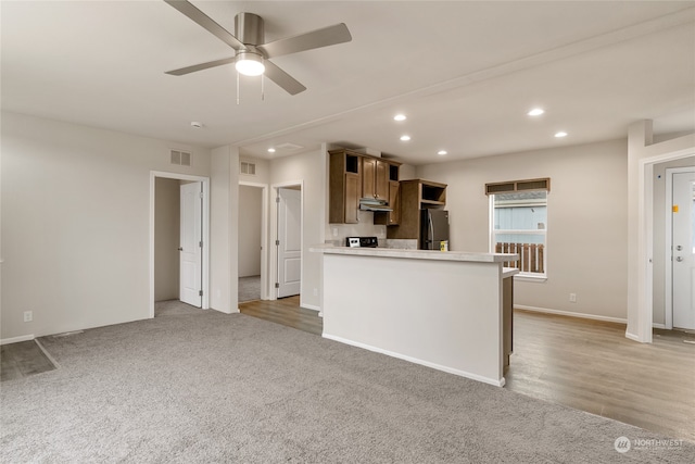 kitchen with light hardwood / wood-style floors, ceiling fan, and stainless steel refrigerator