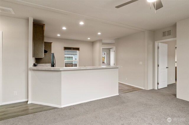 kitchen with stainless steel refrigerator, kitchen peninsula, dark hardwood / wood-style floors, and ceiling fan