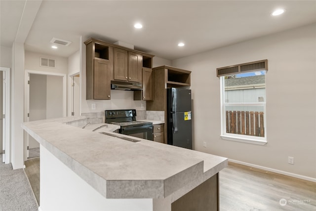 kitchen featuring light hardwood / wood-style flooring, black appliances, and kitchen peninsula