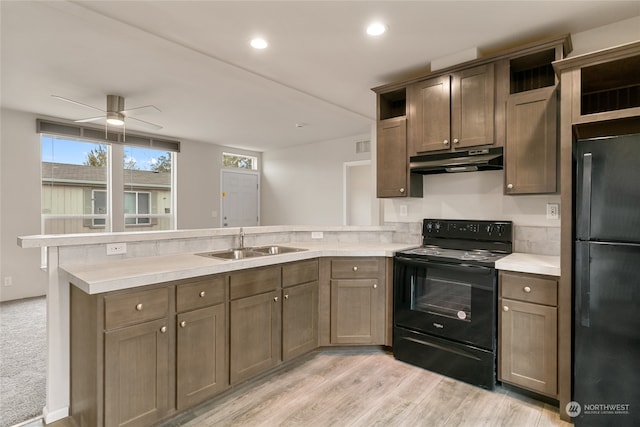 kitchen with kitchen peninsula, sink, black appliances, light hardwood / wood-style floors, and ceiling fan