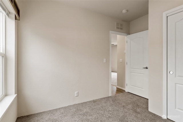 unfurnished bedroom with dark carpet