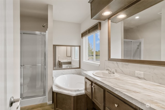 bathroom with vanity, hardwood / wood-style floors, and shower with separate bathtub