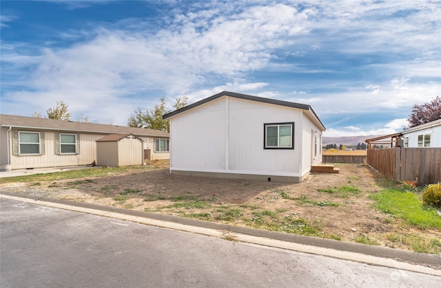 view of side of home featuring a shed