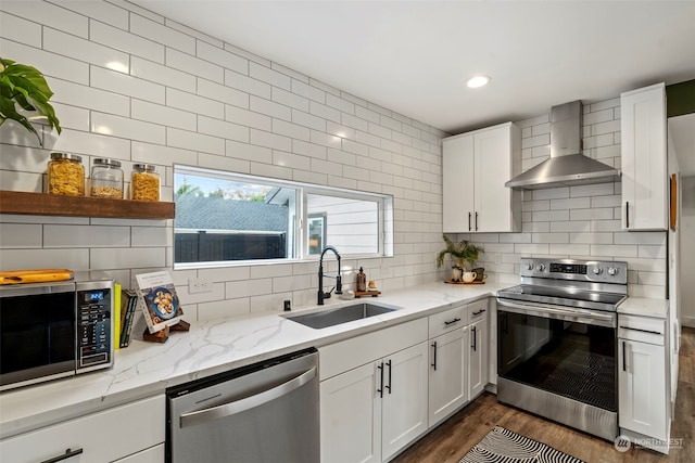 kitchen with stainless steel appliances, sink, wall chimney exhaust hood, white cabinets, and dark hardwood / wood-style flooring