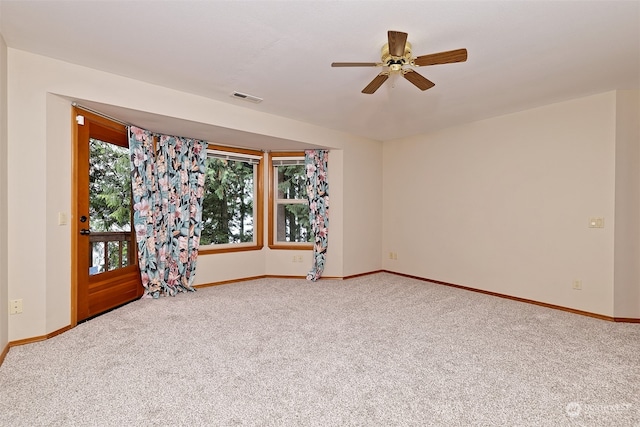 carpeted empty room featuring ceiling fan and a healthy amount of sunlight