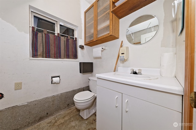 bathroom featuring vanity, toilet, and concrete flooring