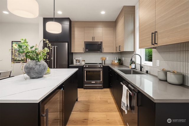 kitchen featuring light brown cabinetry, decorative light fixtures, sink, beverage cooler, and stainless steel appliances