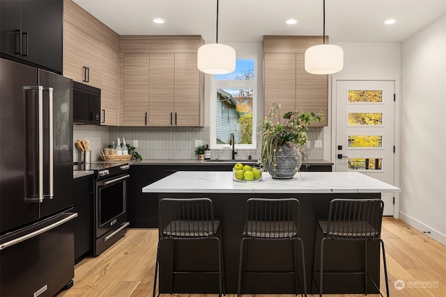 kitchen with high end fridge, pendant lighting, and a kitchen island