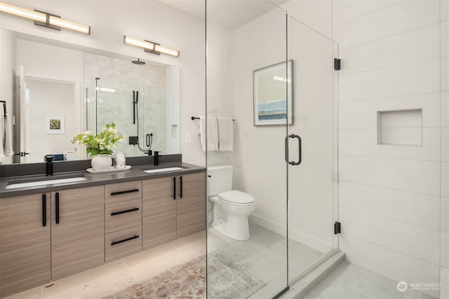 bathroom with vanity, toilet, tile patterned flooring, and a shower with door