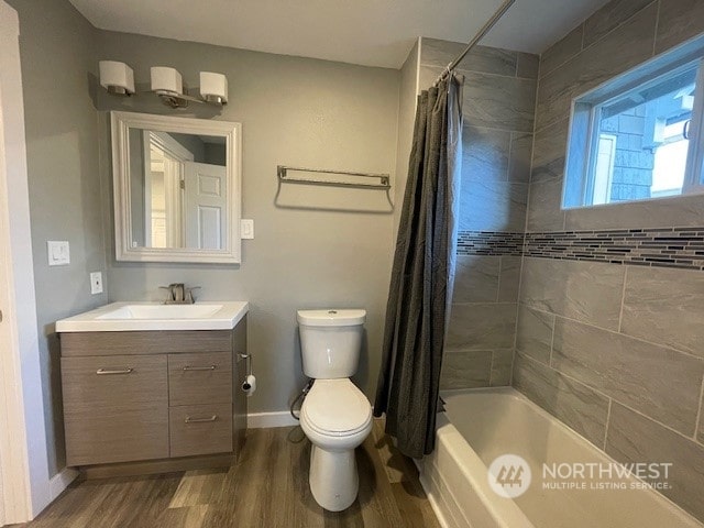 full bathroom with vanity, hardwood / wood-style floors, shower / tub combo, and toilet