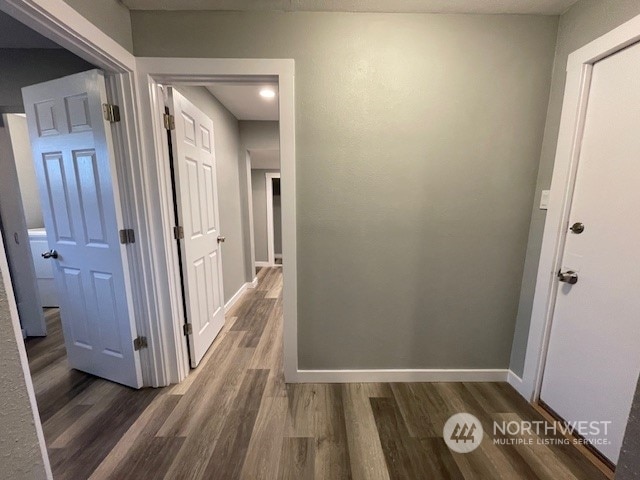 hallway with dark hardwood / wood-style flooring