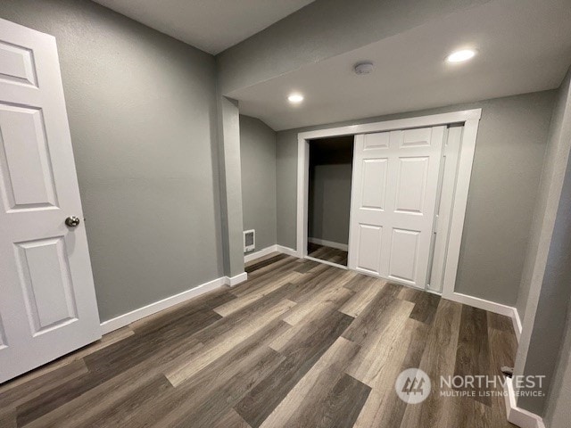 unfurnished bedroom featuring a closet and dark hardwood / wood-style flooring