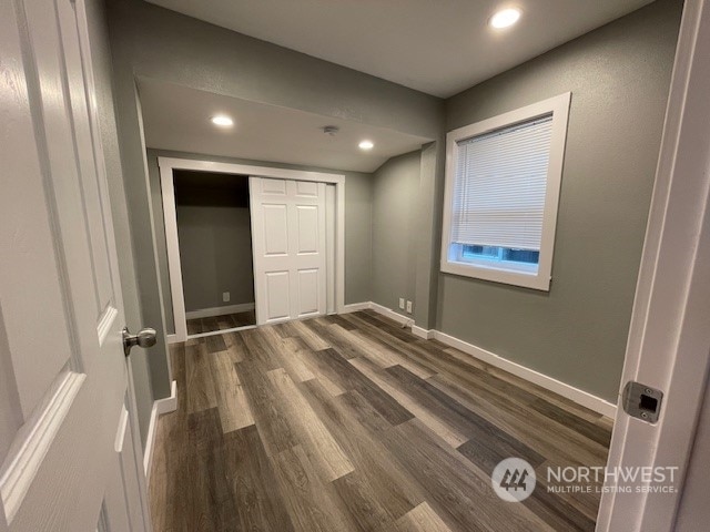 unfurnished bedroom featuring a closet and dark hardwood / wood-style floors