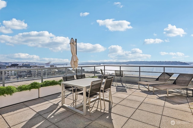 view of patio with a water view and a balcony