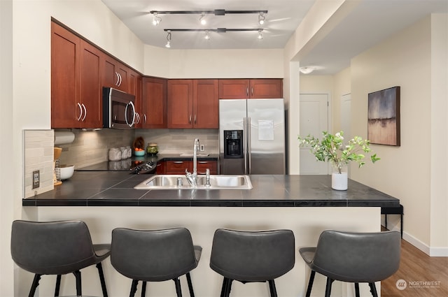 kitchen featuring appliances with stainless steel finishes, sink, kitchen peninsula, and a breakfast bar area