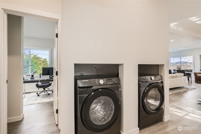 clothes washing area featuring a wealth of natural light and hardwood / wood-style floors