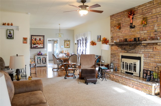 living room featuring ceiling fan, a brick fireplace, and hardwood / wood-style floors