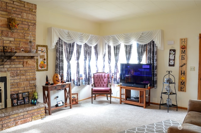 carpeted living room featuring a stone fireplace