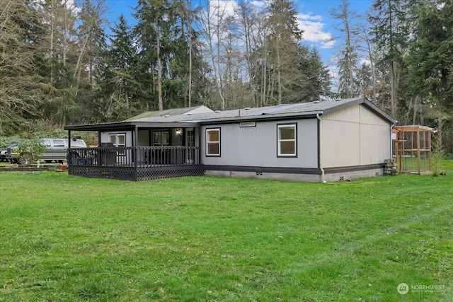 rear view of property with a yard and a deck