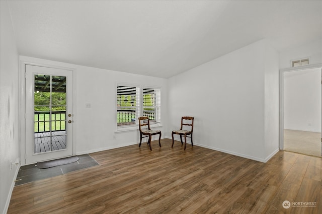 living area featuring dark hardwood / wood-style floors and vaulted ceiling