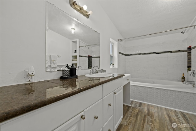 bathroom featuring hardwood / wood-style floors, vanity, and tiled shower / bath combo