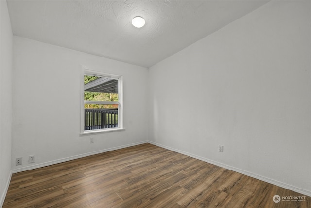 empty room featuring dark hardwood / wood-style floors and lofted ceiling