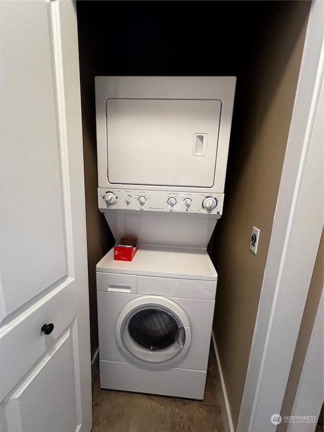 clothes washing area featuring stacked washer and clothes dryer